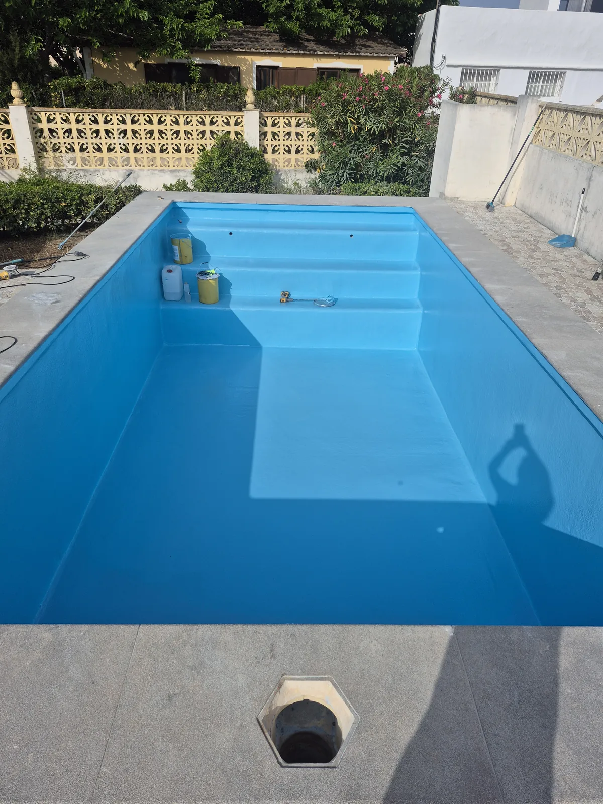Piscina rehabilitada con escalera ancha revestida en azul