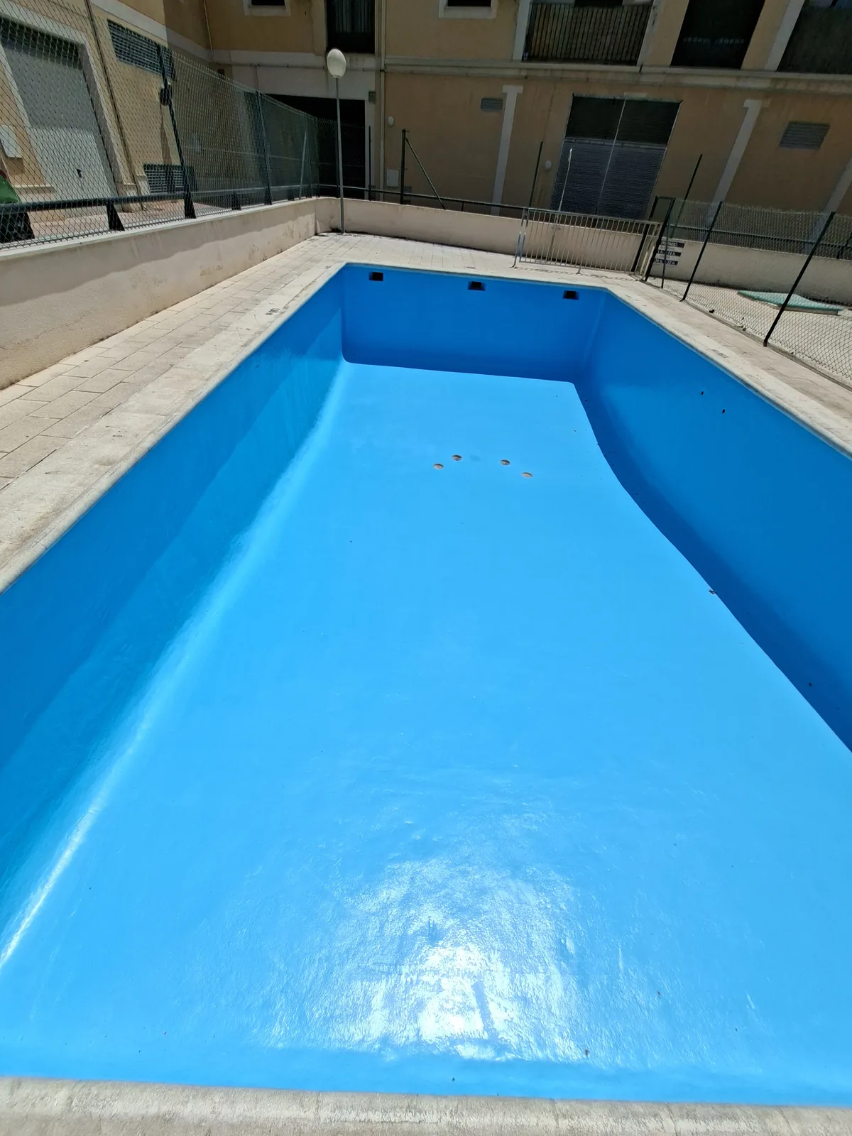 Detalle de una piscina comunitaria rehabilitada con revestimiento de fibra