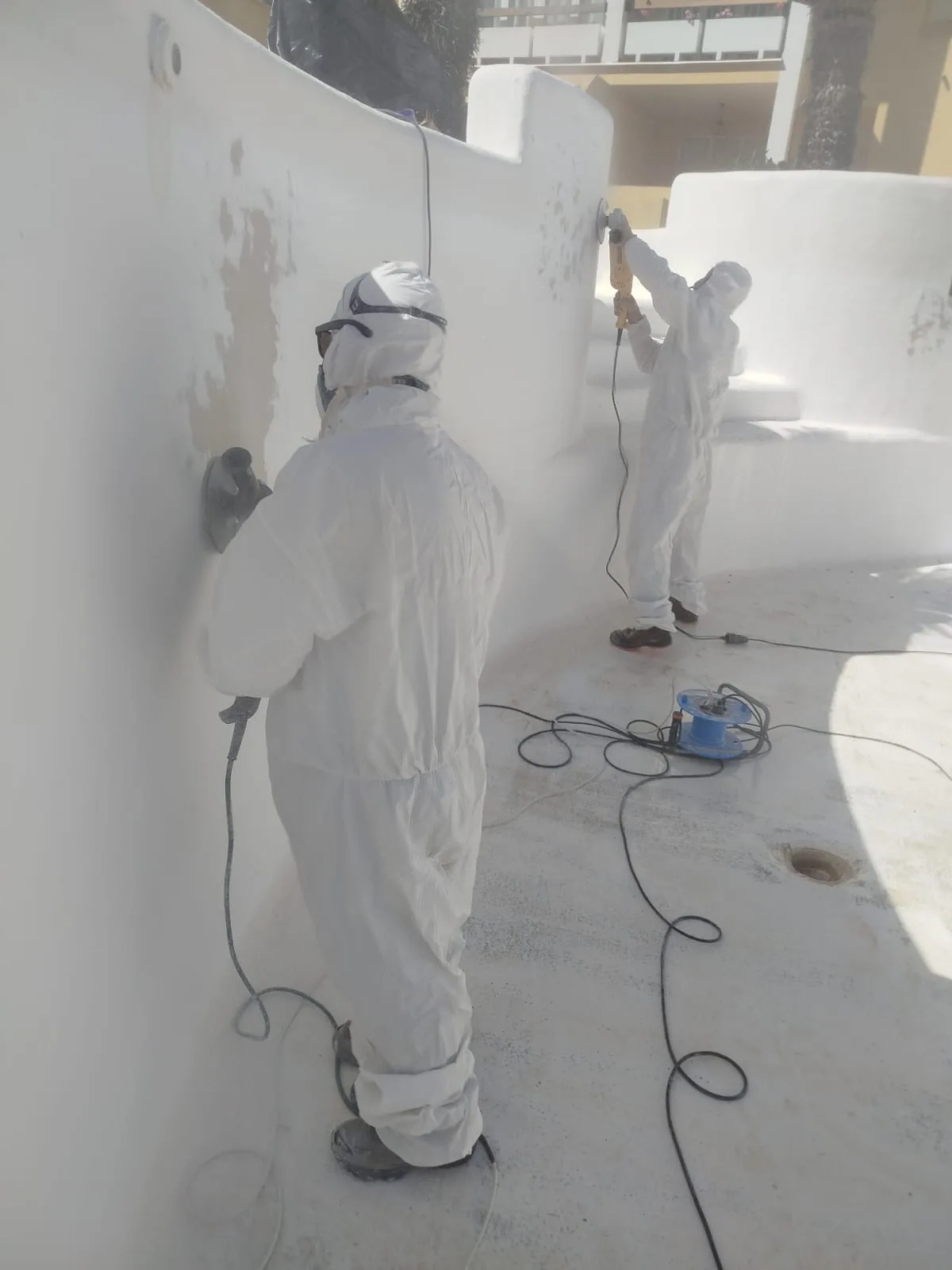 Operarios preparando y lijando el vaso de la piscina antes del revestimiento
