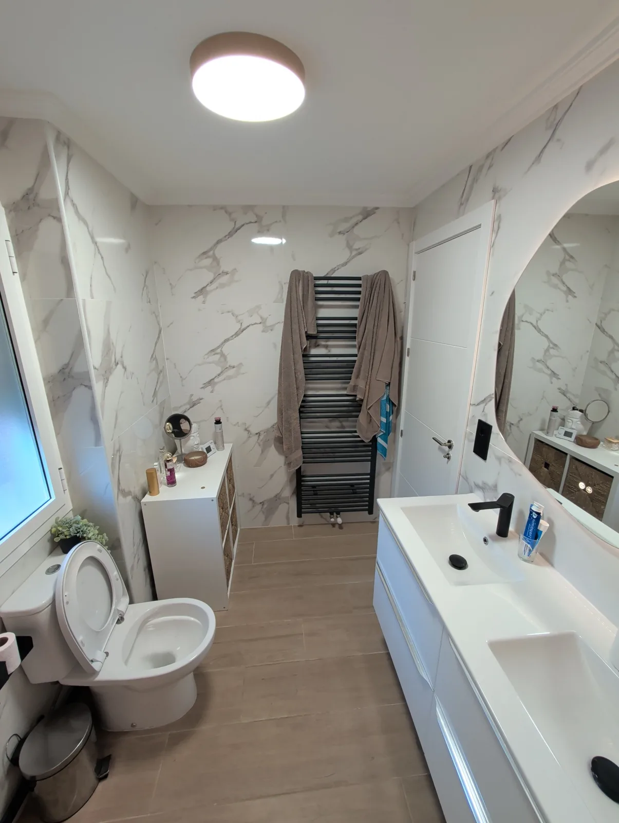 Vista completa del baño terminado con lavabo, inodoro y toallero