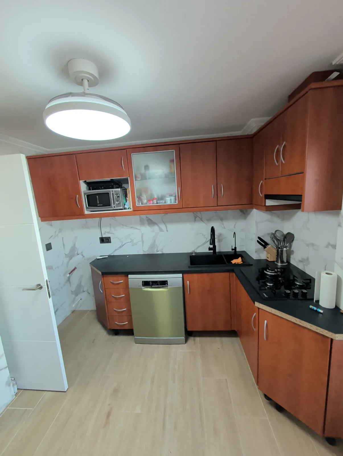 Cocina terminada con encimera negra, suelo y alicatado nuevos