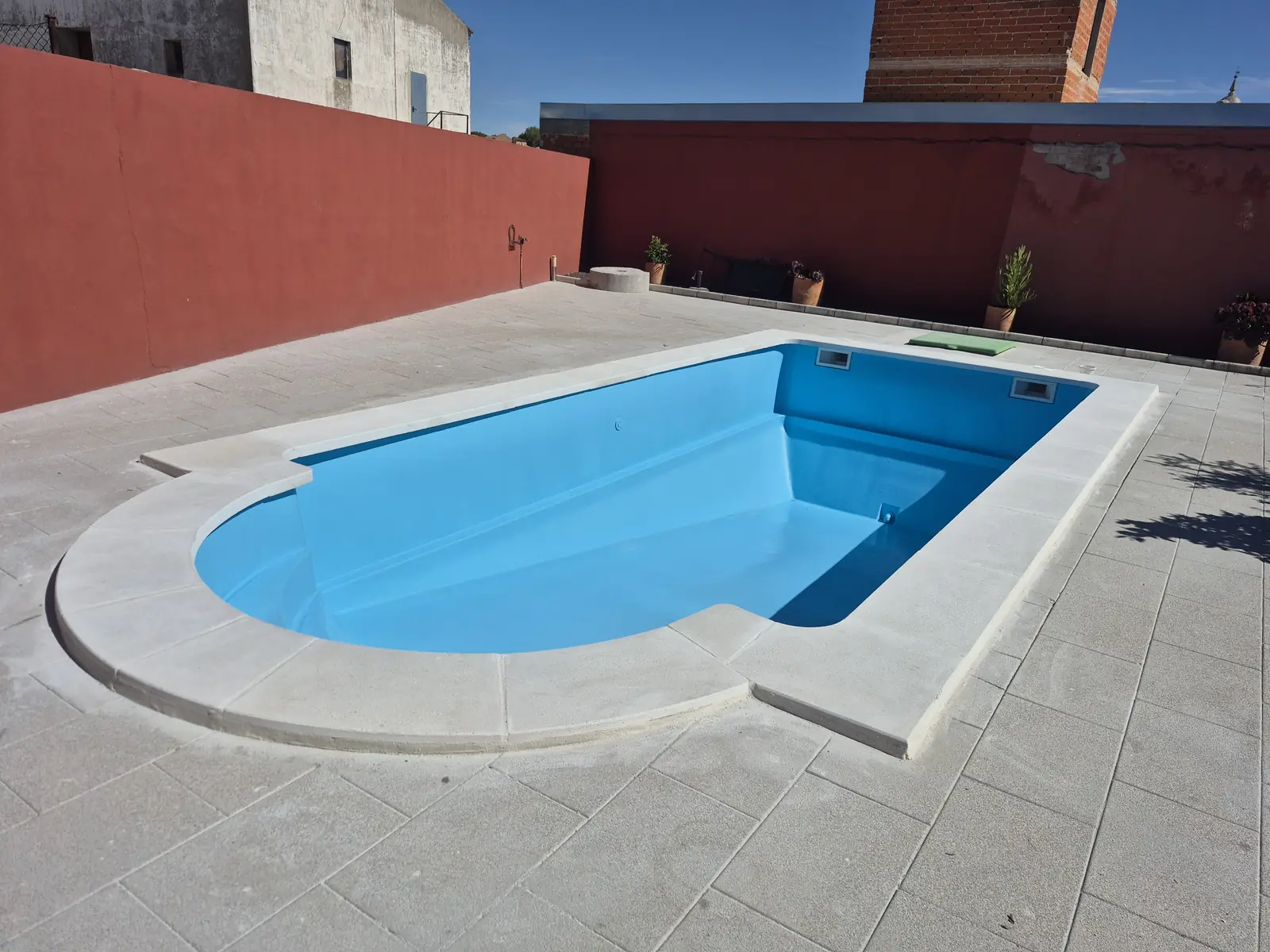 Piscina prefabricada de Esquivias con acabado azul y coronación clara renovada