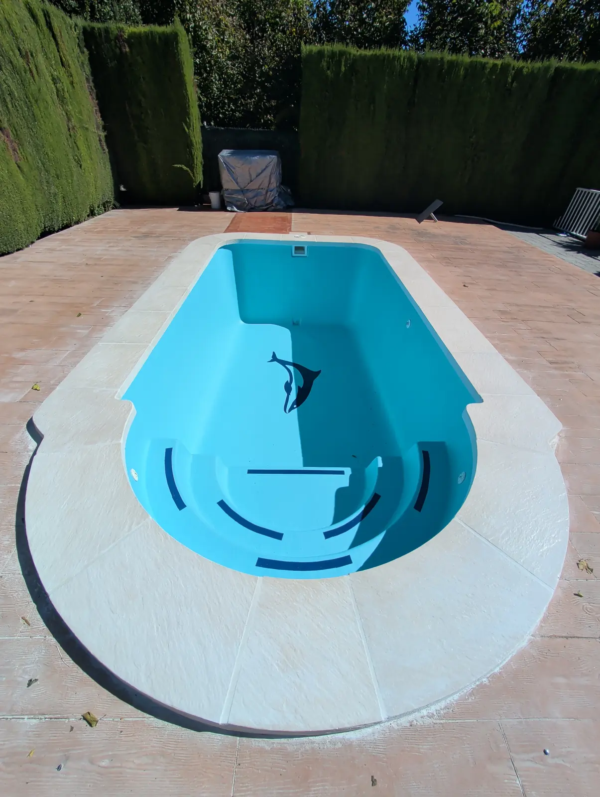 Piscina prefabricada de Sagunto con acabado azul, escalera curva y nueva coronación clara